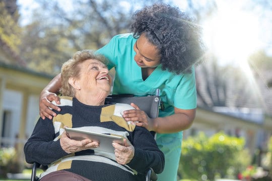 caregiver makes old woman laugh